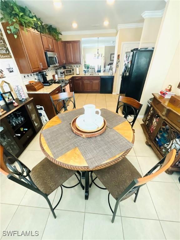 dining space with light tile patterned floors and ornamental molding