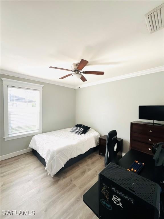 bedroom with light wood-style floors, ceiling fan, visible vents, and crown molding