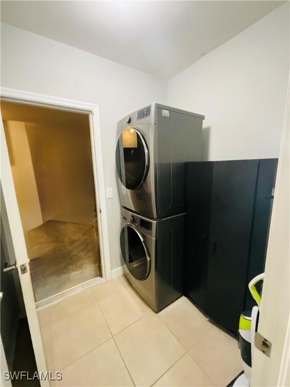 laundry room with laundry area, tile patterned floors, and stacked washer / drying machine