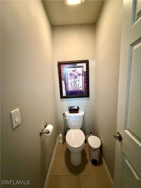 bathroom with toilet, tile patterned flooring, and baseboards