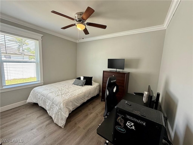 bedroom with a ceiling fan, wood finished floors, baseboards, and ornamental molding