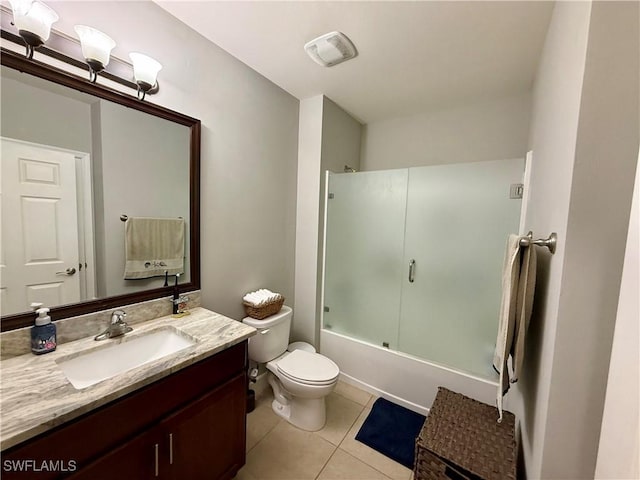 full bath featuring toilet, tile patterned floors, vanity, and bath / shower combo with glass door
