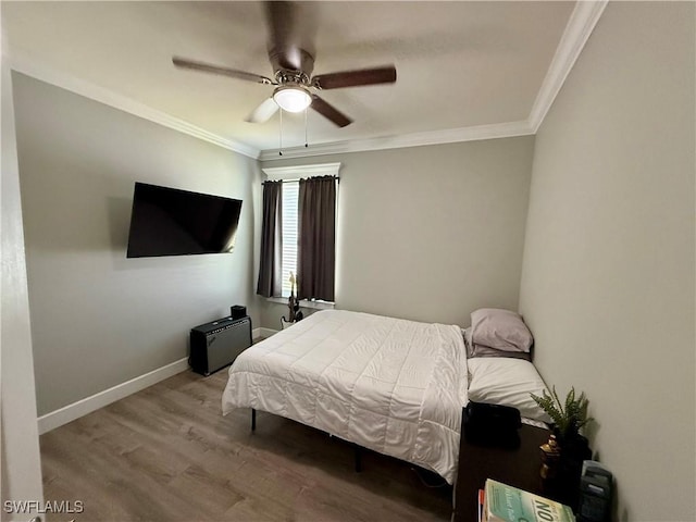 bedroom featuring ceiling fan, baseboards, crown molding, and wood finished floors