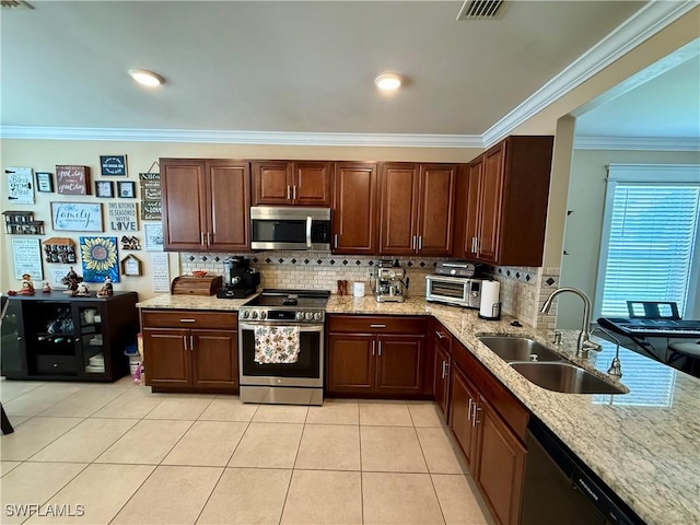 kitchen with a sink, crown molding, stainless steel appliances, backsplash, and light stone counters