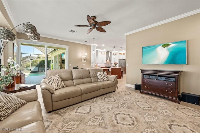 living area featuring light tile patterned floors, visible vents, baseboards, a ceiling fan, and crown molding