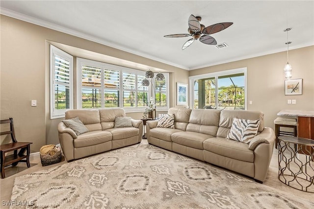 living room featuring visible vents, crown molding, baseboards, and ceiling fan