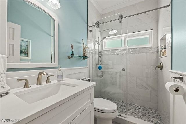 bathroom with a stall shower, wainscoting, vanity, and toilet