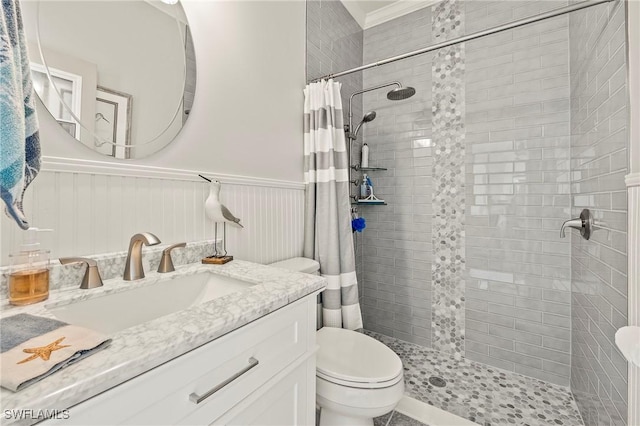 bathroom featuring vanity, wainscoting, a shower stall, and toilet