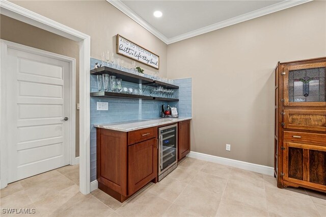 bar with wine cooler, ornamental molding, light tile patterned flooring, a bar, and baseboards