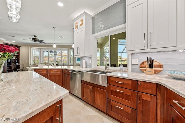 kitchen featuring dishwasher, light stone counters, ornamental molding, white cabinetry, and a sink