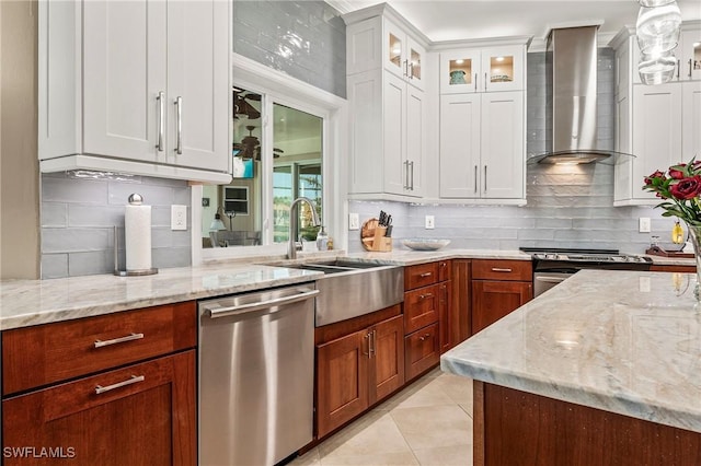 kitchen featuring wall chimney exhaust hood, appliances with stainless steel finishes, light stone countertops, white cabinetry, and light tile patterned flooring