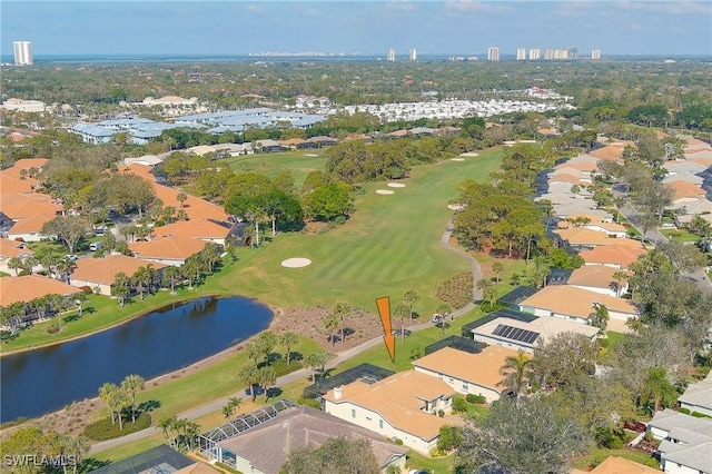 drone / aerial view featuring a water view, view of golf course, and a residential view