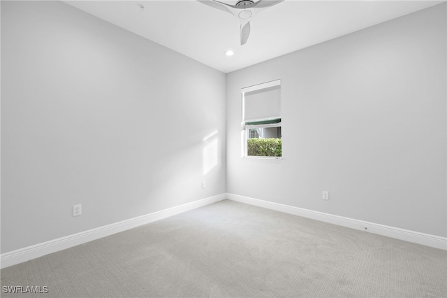 spare room featuring baseboards, recessed lighting, and light colored carpet