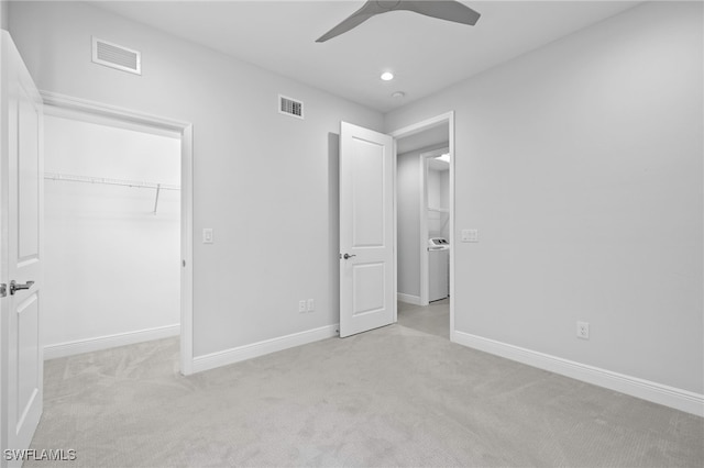 unfurnished bedroom with baseboards, a spacious closet, visible vents, and light colored carpet