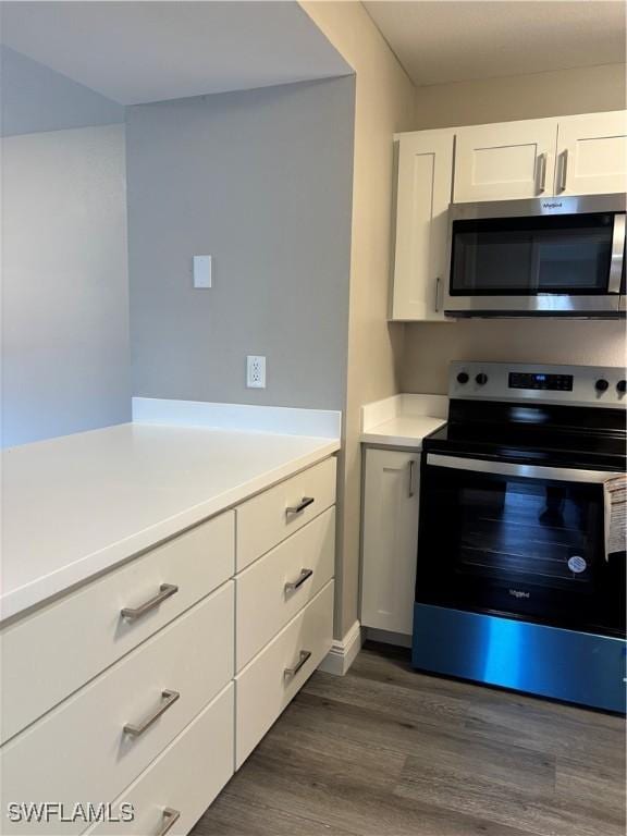 kitchen featuring white cabinetry, light countertops, dark wood finished floors, and appliances with stainless steel finishes