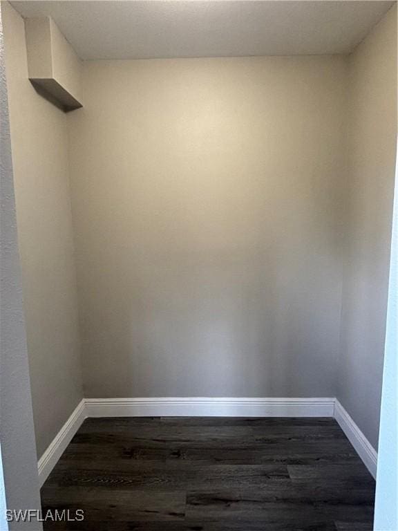 empty room with baseboards and dark wood-style flooring