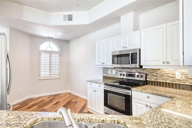kitchen with visible vents, tasteful backsplash, appliances with stainless steel finishes, and white cabinetry