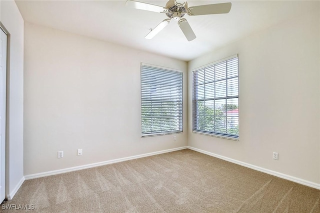 unfurnished room featuring baseboards, carpet floors, and ceiling fan