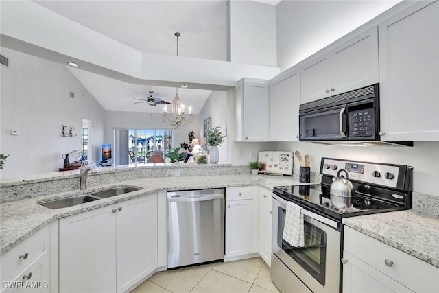 kitchen with a chandelier, a sink, vaulted ceiling, appliances with stainless steel finishes, and light stone countertops