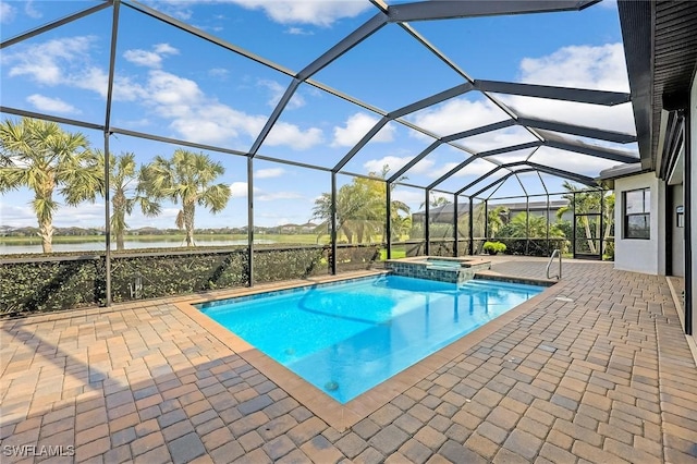 view of pool featuring a patio area, glass enclosure, a pool with connected hot tub, and a water view
