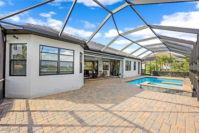 view of swimming pool with glass enclosure, a pool with connected hot tub, and a patio area