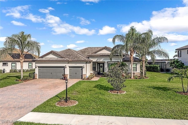view of front of property featuring a front yard, stucco siding, a garage, a tiled roof, and decorative driveway