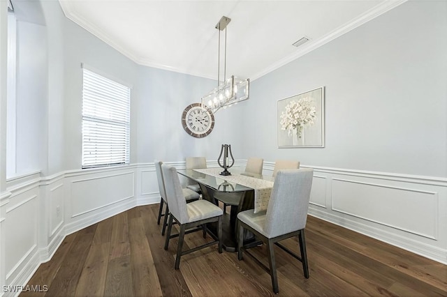 dining area with dark wood finished floors, a notable chandelier, visible vents, and ornamental molding