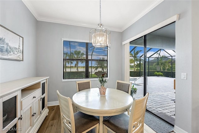 dining area with a chandelier, plenty of natural light, dark wood-style floors, and ornamental molding