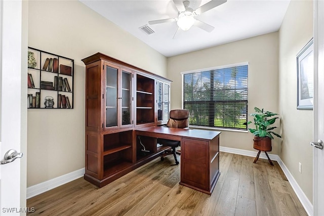 office area with light wood-style flooring, a ceiling fan, visible vents, and baseboards