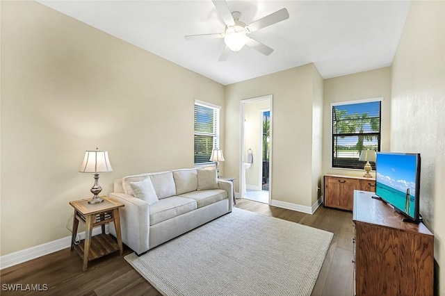 living room featuring a ceiling fan, baseboards, and dark wood-style flooring