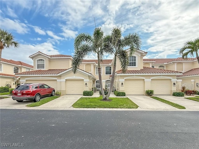 townhome / multi-family property featuring a garage, a tile roof, concrete driveway, and stucco siding