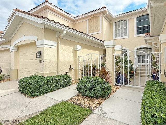 exterior space featuring a garage, a gate, a tiled roof, and stucco siding