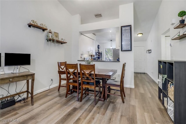 dining space featuring wood finished floors, visible vents, and baseboards