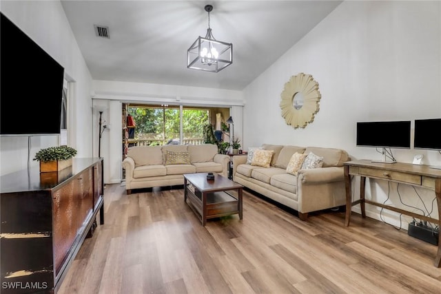 living room with visible vents, a notable chandelier, vaulted ceiling, and light wood-style flooring