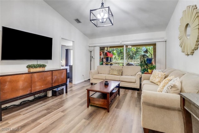 living area with lofted ceiling, visible vents, a chandelier, light wood-type flooring, and baseboards