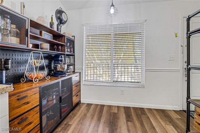 kitchen with open shelves, dark wood-type flooring, light countertops, and baseboards