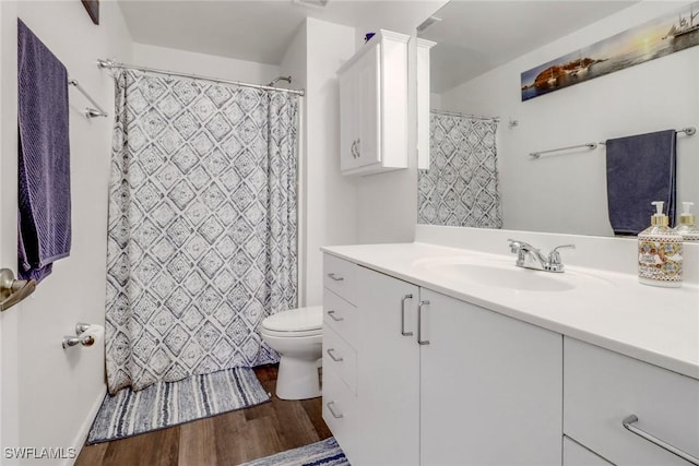 bathroom featuring vanity, a shower with shower curtain, wood finished floors, and toilet