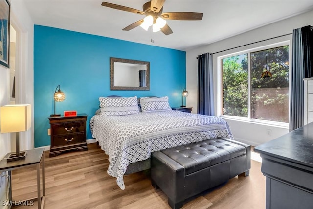 bedroom with ceiling fan, baseboards, and wood finished floors