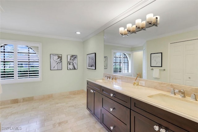 bathroom with ornamental molding, a sink, baseboards, and double vanity