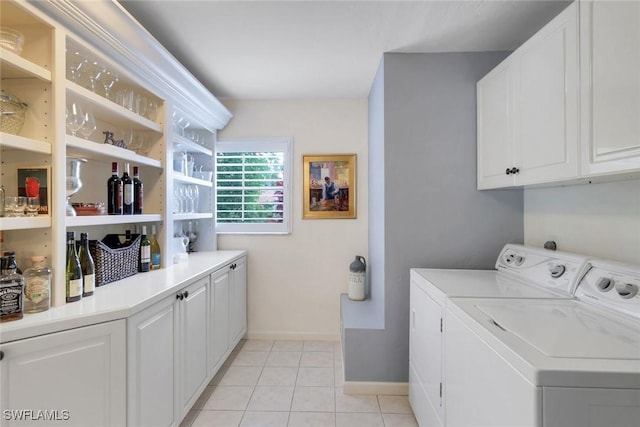 washroom with washer and clothes dryer, light tile patterned flooring, cabinet space, and baseboards