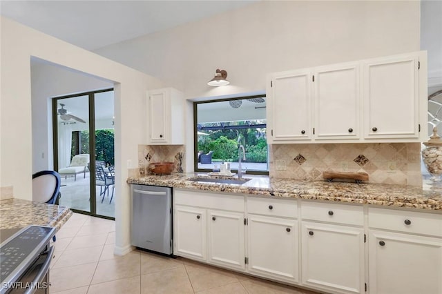 kitchen with a sink, white cabinetry, appliances with stainless steel finishes, light stone countertops, and plenty of natural light