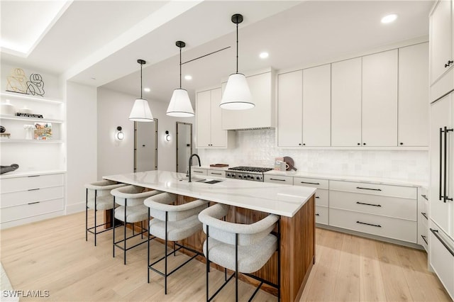 kitchen with a breakfast bar, a sink, and light wood-style floors