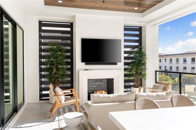 living room with recessed lighting, wood ceiling, and a lit fireplace