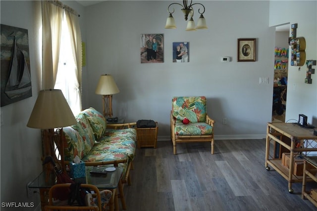 living area featuring a chandelier, wood finished floors, and baseboards