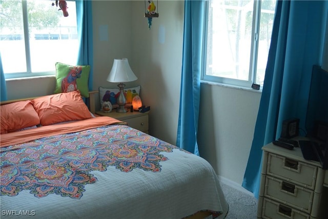 bedroom featuring carpet floors, multiple windows, and baseboards