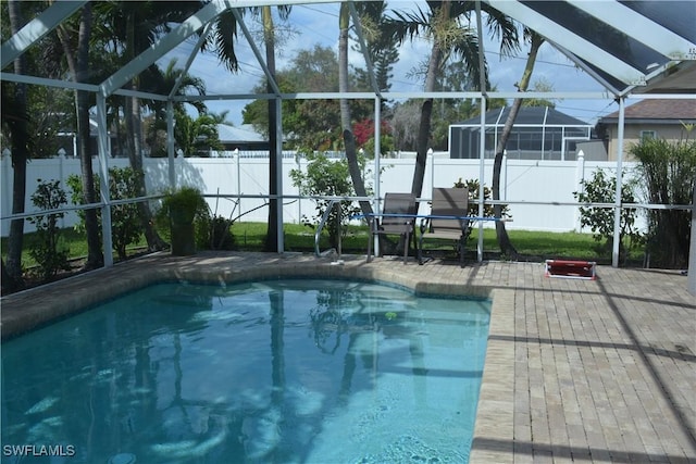 view of swimming pool featuring a lanai, a fenced backyard, a fenced in pool, and a patio