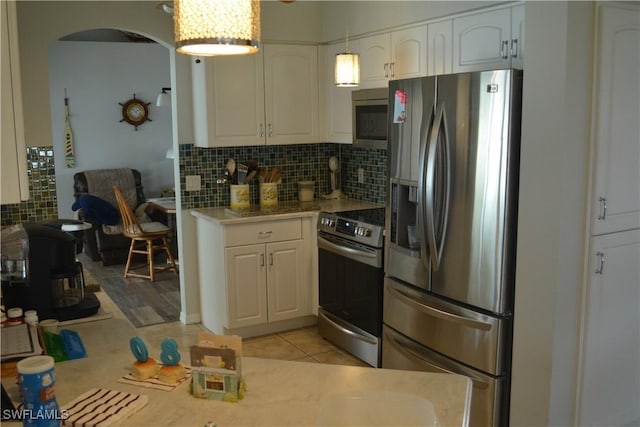 kitchen featuring white cabinets, stainless steel appliances, backsplash, and light countertops