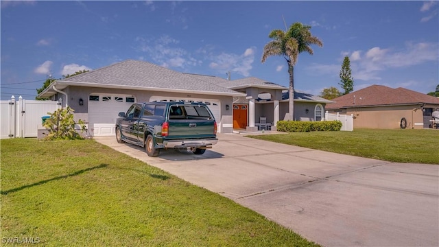 view of front of house featuring stucco siding, a gate, concrete driveway, a front yard, and a garage