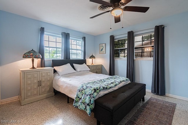 bedroom featuring ceiling fan, speckled floor, and baseboards