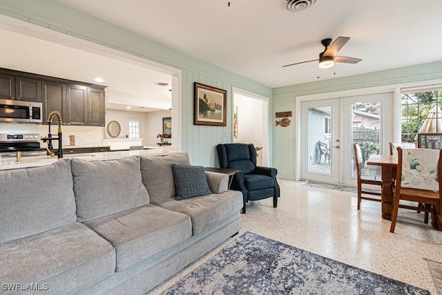 living room with plenty of natural light, visible vents, french doors, and speckled floor